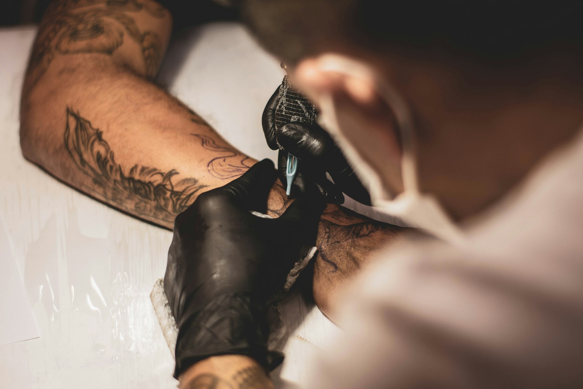 Tätowierer bei der präzisen Arbeit an einem Black-and-Grey-Tattoo im Tattoo Studio Karizma